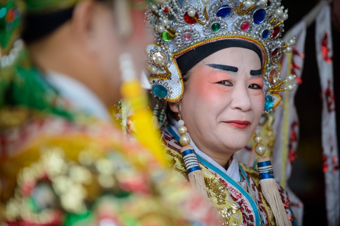 A Chinese Opera performer shares a secret smile. Image: Altai World Photography.